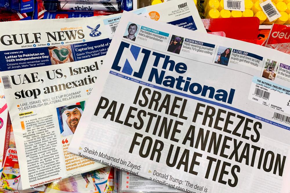 This picture taken on August 14, 2020 in Dubai shows the front pages of UAE-based The National and Gulf News newspapers with their headlines reflecting the announcements on the previous day as Israel and the UAE agreed to normalise relations in a landmark US-brokered deal. - AFP