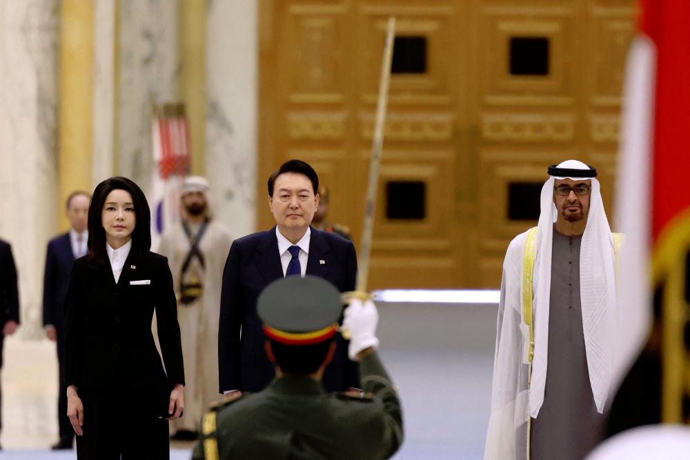 Sheikh Mohamed (right) walks alongside Yoon Suk-yeol and his wife Kim Keon-hee during a welcome ceremony at the royal palace in Abu Dhabi, on Sunday. – AFPpic