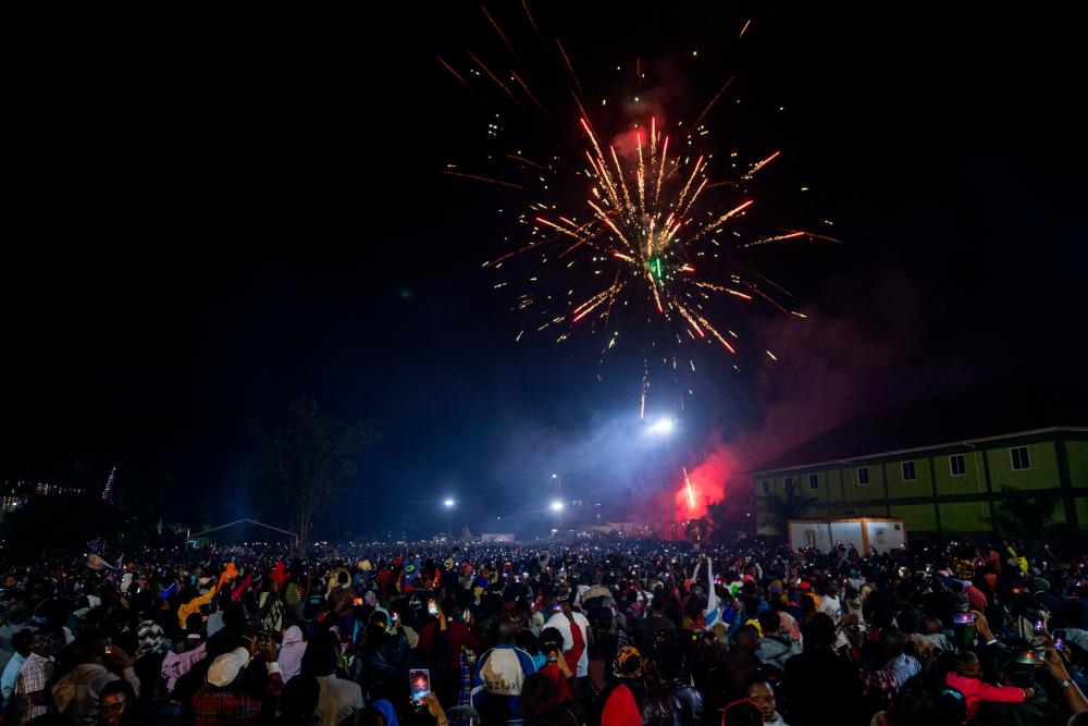 Fireworks light up the sky as people react while they celebrate after counting down to the new year at Miracle Center Cathedral in Kampala, Uganda, on January 1, 2023. AFPPIX