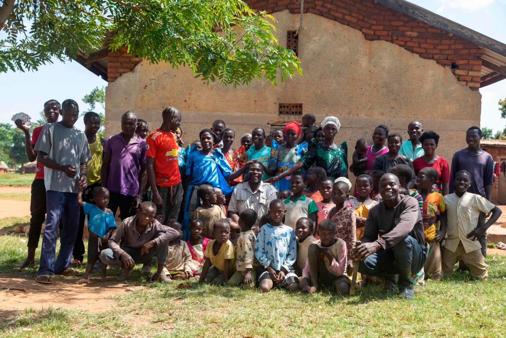 Musa Hasahya (C) pose for a picture with some of his wives, children and grandchildren outside their family home in Butaleja district in Eastern Uganda, on January 17, 2023. AFPPIX