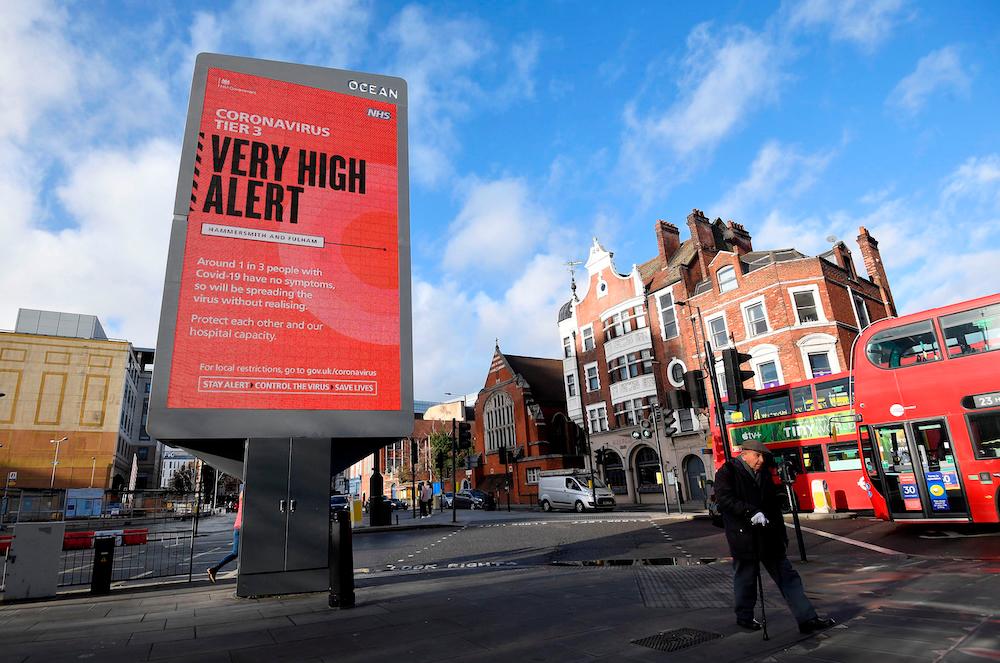 Pedestrians walk past a British government health information advertisement highlighting new restrictions amid the spread of the coronavirus disease, London, Britain, December 19, 2020. ― Reuters