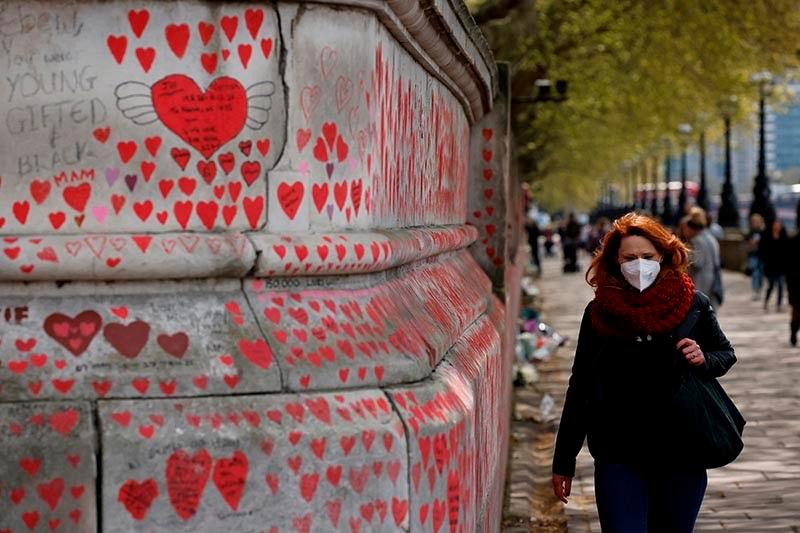 A woman looks at the hearts and messages on the National Covid Memorial Wall on the embankment on the south side of the River Thames in London on April 30, 2021 in memory of those who lost their lives to COVID-19. – AFP
