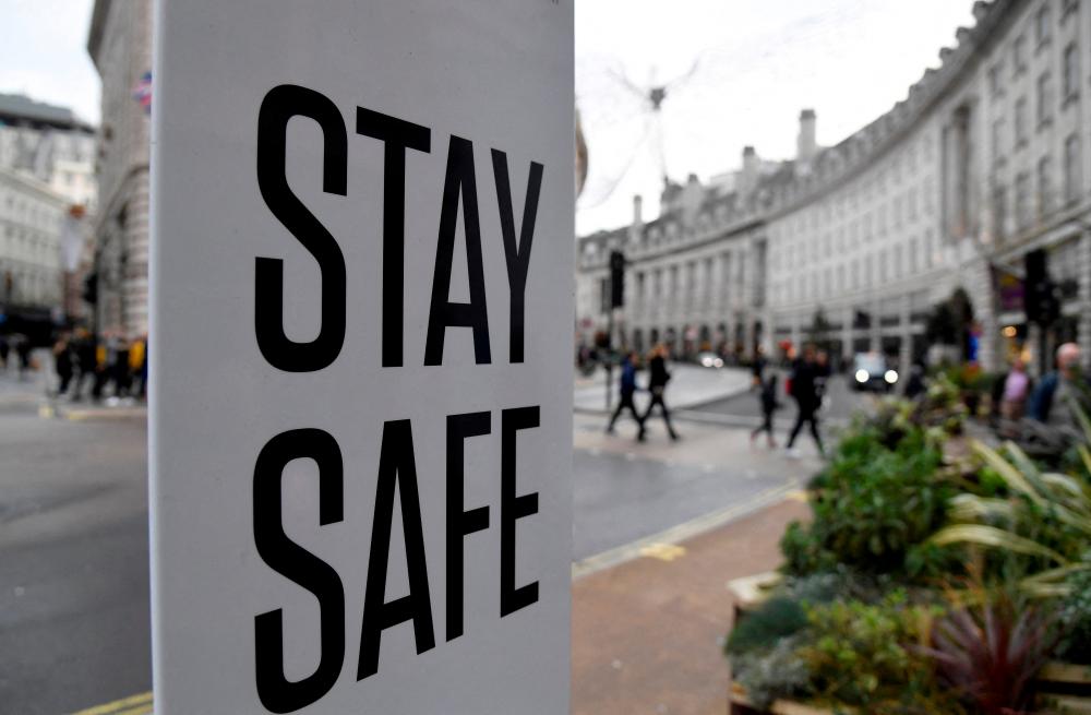 FILE PHOTO: A public health sign is seen amidst the spread of the coronavirus disease (Covid-19) pandemic, in London, Britain, December 28, 2021. REUTERSpix
