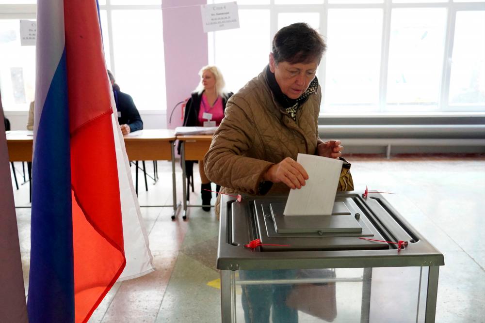 A woman casts her ballot for a referendum at a polling station in Mariupol on September 27, 2022. AFPPIX