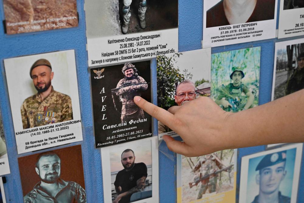 Erika Martyniuk shows the photograph of her late husband Savely Fedan on the Memory Wall of Fallen Defenders of Ukraine during an interview with AFP in Kyiv on September 14, 2023, amid the Russian invasion of Ukraine. AFPPIX