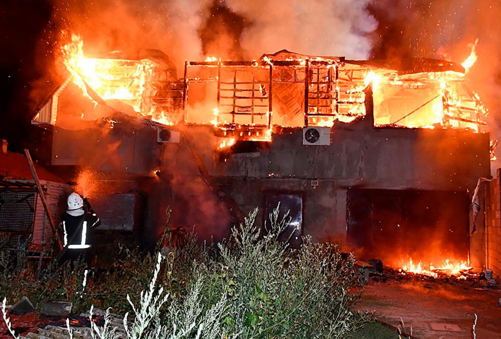 A firefighter facing a fire in front of a burning residential building after a shelling in Mykolaiv region, amid the Russian invasion of Ukraine. AFPPIX