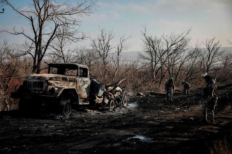 This handout photograph taken on January 10, 2025 and released by the press service of the 24th Mechanized Brigade of Ukrainian Armed Forces on January 13, 2025 shows servicemen of engineer supply group of 24th Mechanized Brigade checking a road next to a burned military vehicle near Chasiv Yar town, in the Donetsk region, Ukraine. - AFP PHOTO / PRESS SERVICE OF THE 24TH MECHANIZED BRIGADE OF UKRAINIAN ARMED FORCES