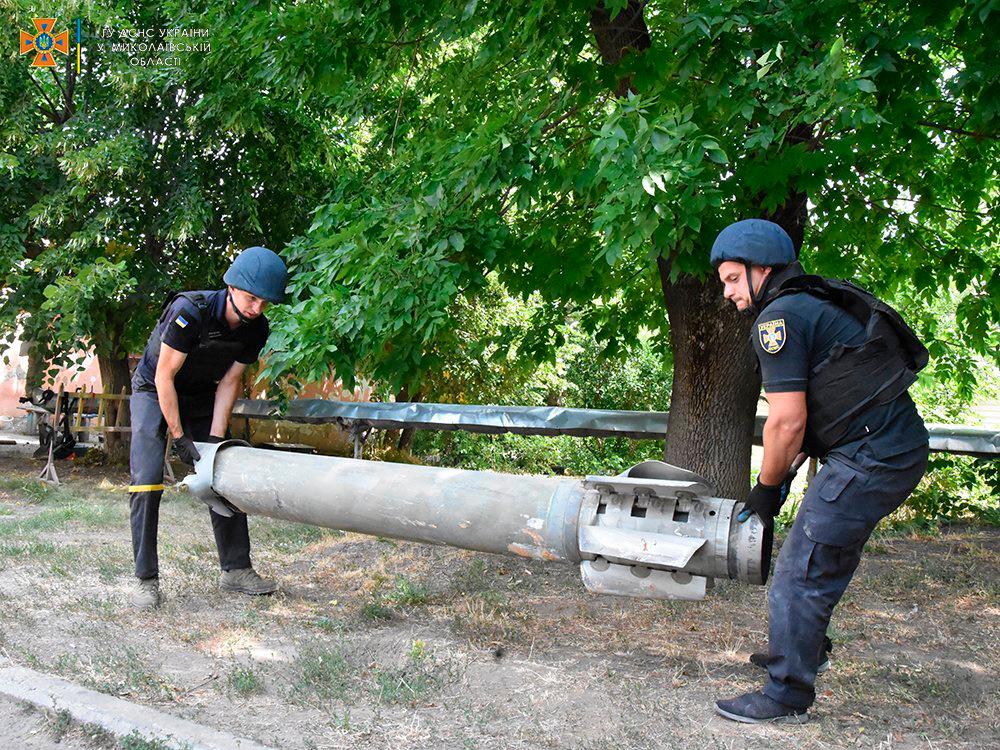 This handout picture taken and released by Ukrainian Emergency Service on July 31, 2022 shows resquers carrying fragment of a missile in an open air sport ground after a strike in Mykolaiv. AFPPIX