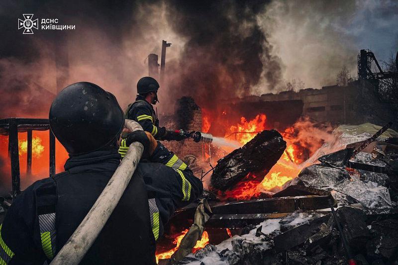 This handout photograph taken and released by the State Emergency Service of Ukraine on November 13, 2024, shows firefighters extinguishing fire following a Russian strike in Brovary, near Kyiv, amid the Russian invasion of Ukraine. Rusia escalated its attacks on Kyiv early November 13, launching waves of drones and missiles in its first combined aerial assault on the capital in more than 70 days, authorities said. - AFP PHOTO / State Emergency Service of Ukraine