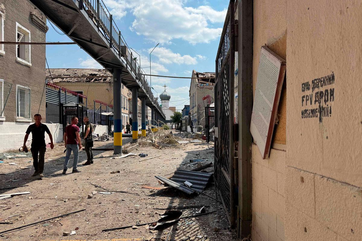 Ukrainian law enforcement officers walk past damaged buildings of the Bilenkivska correctional colony following an air attack in Bilenke, Zaporizhzhia region - AFPPix