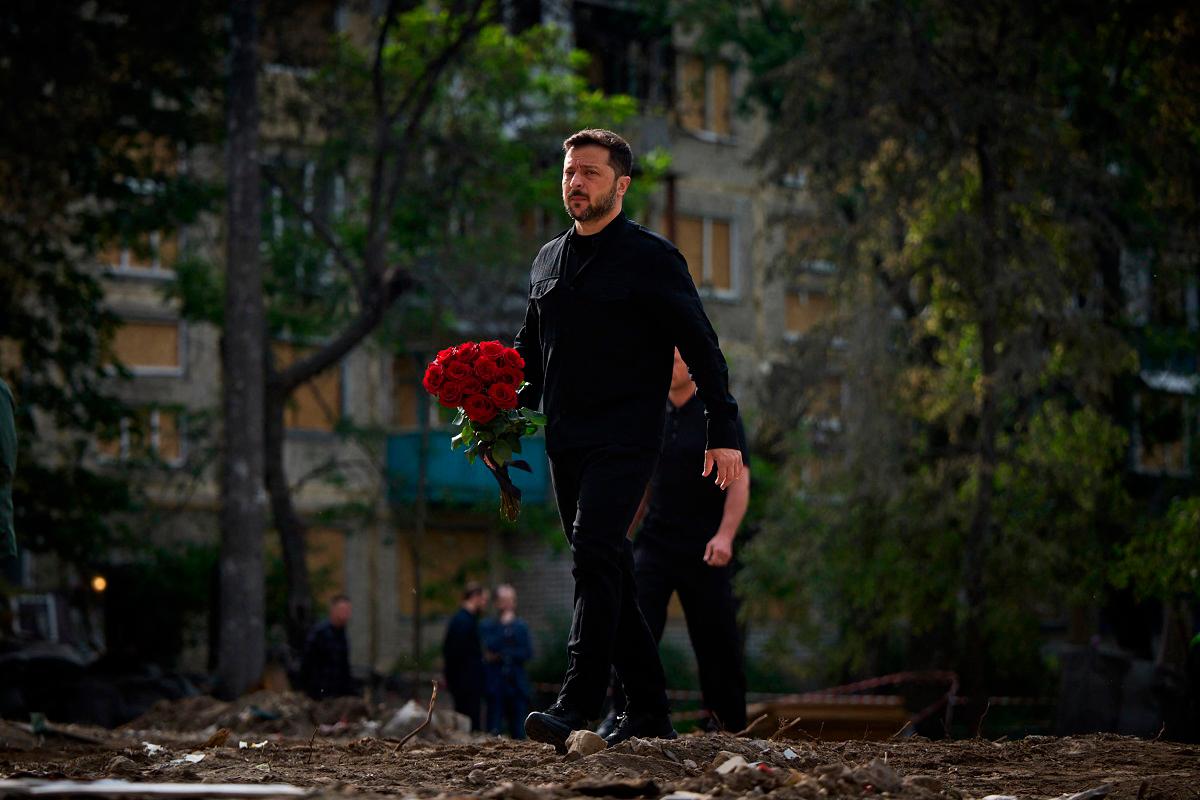 Ukraine’s President Volodymyr Zelensky arrives to lay a wreath of flowers to honour the memory of victims in front of a residential building in the Solomianskyi district of Kyiv on June 19, 2025, that was damaged following an attack on June 17, 2025. - AFP PHOTO / HANDOUT / UKRAINE PRESIDENCY