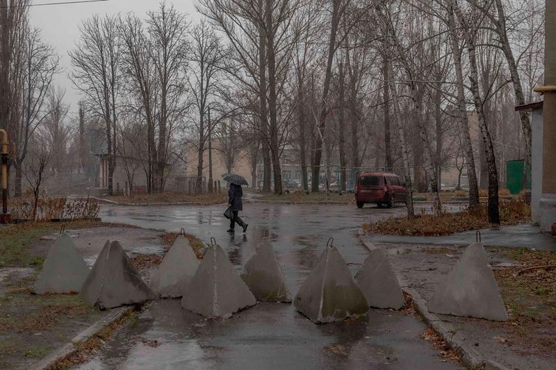 A local resident walks past dragon's teeth fortifications installed by the Ukrainian army on the street in Pokrovsk, the eastern Donetsk region, on December 11, 2024, amid the Russian invasion of Ukraine. The sound of heavy fighting could be heard on December 11, 2024 around Ukraine's frontline city of Pokrovsk, in the Donetsk region, as the Ukrainian army has been trying to hold off the Russian offensive. Moscow has been advancing in the east of Ukraine for months, pressing its advantage against overstretched and outgunned Ukrainian soldiers. - Roman PILIPEY / AFP