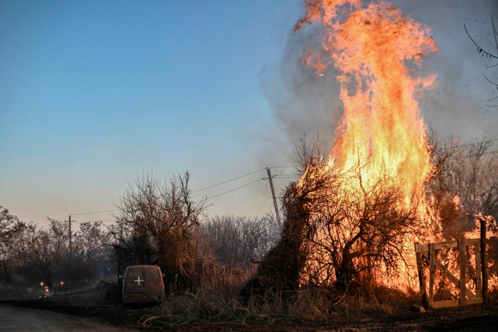 Trees burn next to a Ukrainian military vehicle, after white phosphorus munitions exploded in the air, at the village of Chasiv Yar near Bakhmut, on March 14, 2023, amid the Russian invasion of Ukraine. AFPPIX