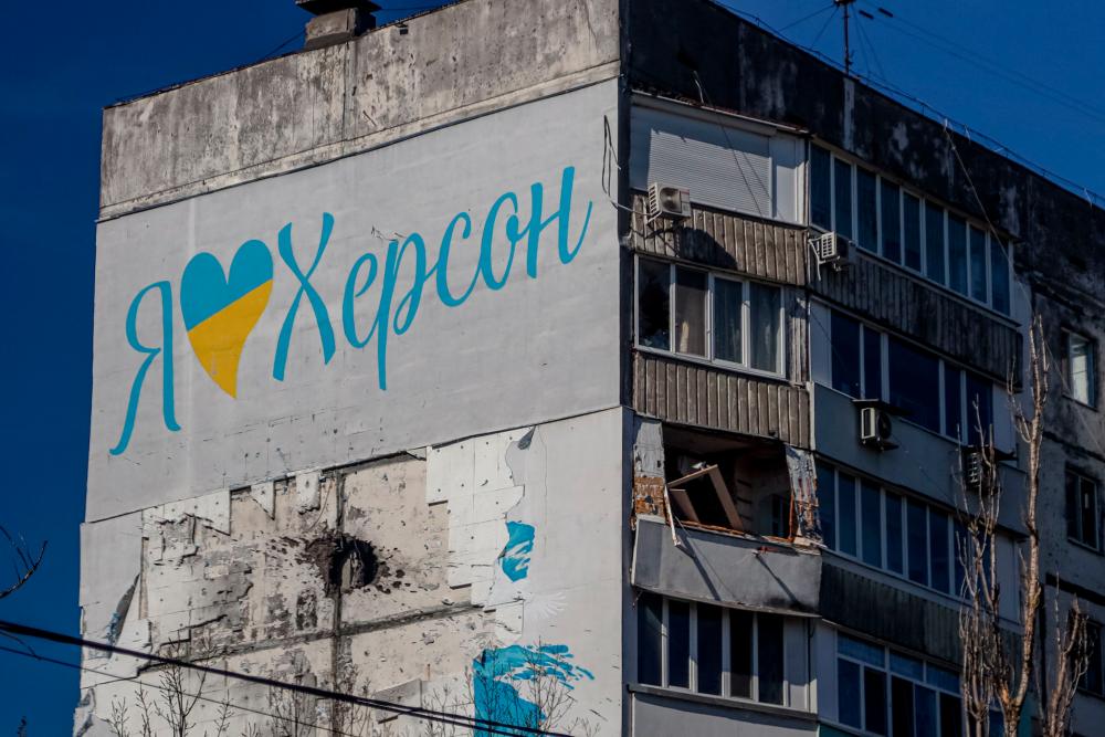 A damaged residenial building in the city of Kherson, with the slogan “I love Kherson” just above a hole from artillery shelling on March 14, 2023, amid the Russian invasion of Ukraine. AFPPIX