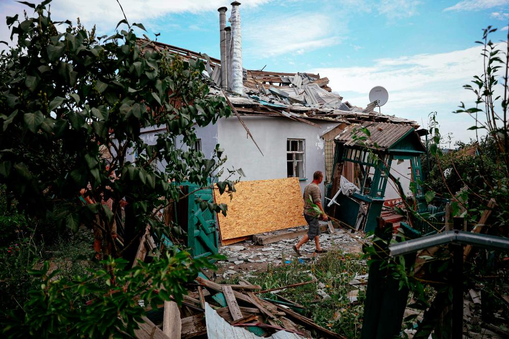 A man walks in front of a destroyed building following a rocket attack in the town of Kramatorsk in Donetsk region on August 13, 2022, amid the Russian military invasion of Ukraine. - AFPPIX
