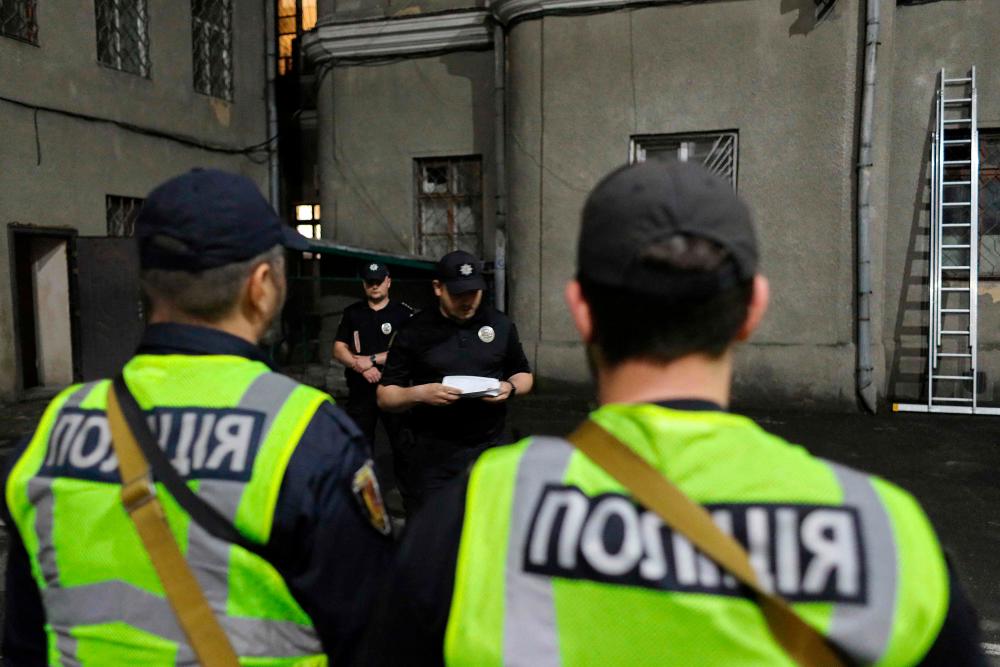 Ukrainian police officers attend a briefing prior to their night shift in the southern Ukrainian port city of Odesa, on May 25, 2023, amid the Russian invasion of Ukraine. As the war broke out, figures in high-level, international organised crime groups left Russia and Ukraine for places like Central Asia and the Gulf states. AFPPIX
