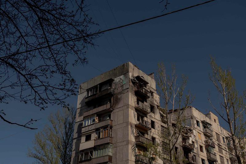 People walk past residential buildings heavily damaged by air attacks in Kostyantynivka, in the eastern Donetsk region, on April 20, 2025, amid the Russian invasion of Ukraine. Russia and Ukraine accused each other of violating an Easter truce announced by Russian President. - Roman PILIPEY / AFP