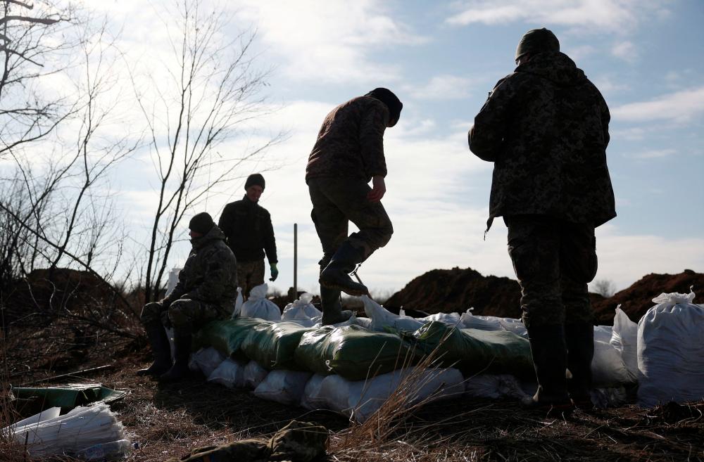 Ukrainian servicemen pile up earthbags to build a fortification not far from town of Avdiivka in the Donetsk region, amid the Russian invasion of Ukraine, on February 17, 2024/AFPPix