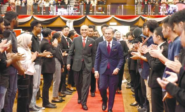 MSU president and founder Tan Sri Prof Dr Mohd Shukri Ab Yajid escorting Fahmi into the event venue.