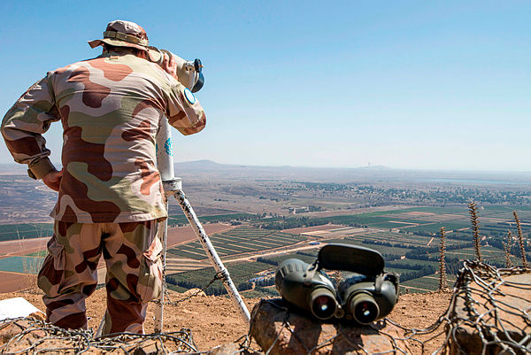 a European member of the United Nations Disengagement Observer Force (Undof) using binoculars to look towards the Syrian side of the Golan Heights as he stands in the Israeli-occupied Golan Heights. Israeli Prime Minister Benjamin Netanyahu — AFP