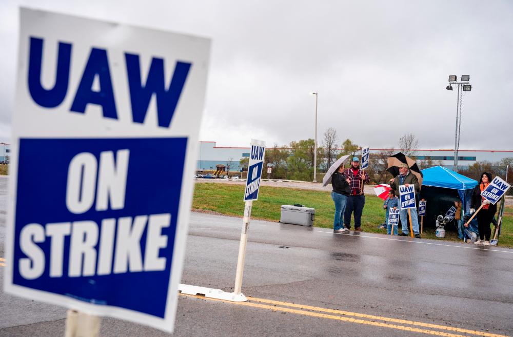Union members picket GM in the midst of a tentative deal being reached with the UAW on Monday. The union has officially suspended its strike against the Detroit Three. – Reuterspic