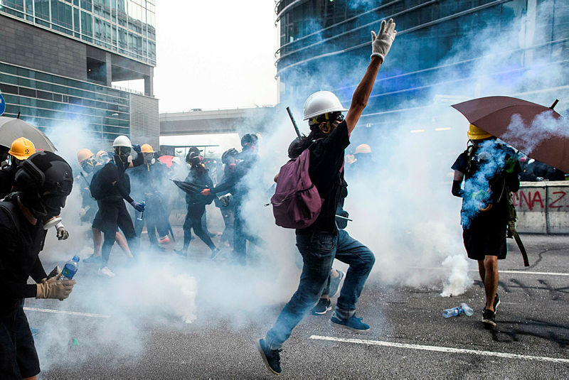 Protesters reacts as Police fire tear gas towards them in Kowloon Bay in Hong Kong on Aug 24, 2019. — AFP