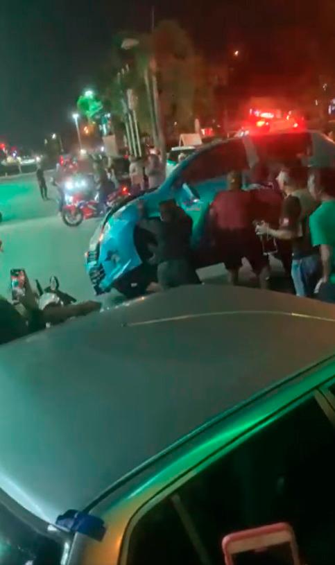 The video footage showing rioters flipping the car while being cheered on by others. – Facebook/@navin.navinkumar.98434