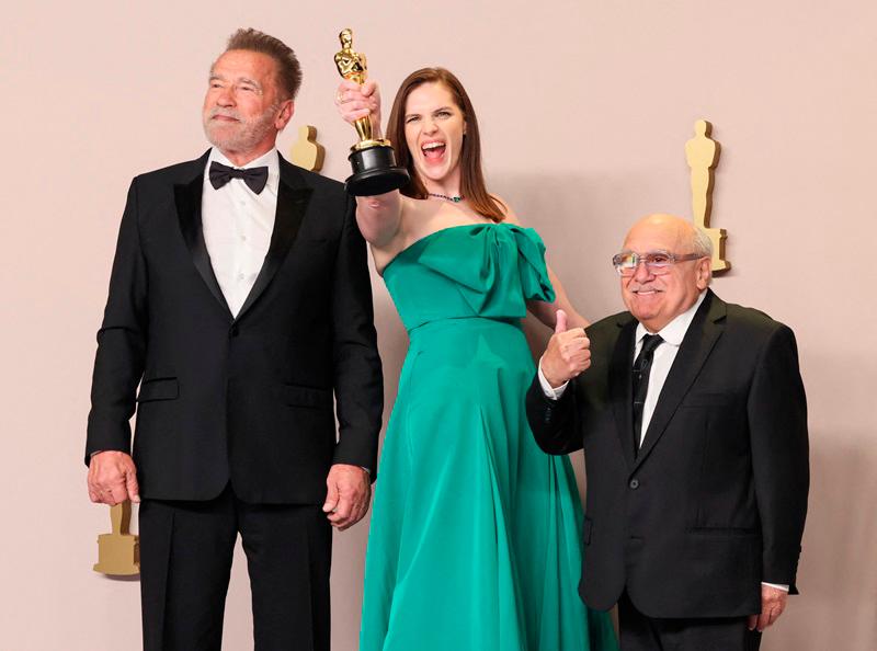 $!Arnold Schwarzenegger, Jennifer Lame, winner of the Best Film Editing award for “Oppenheimer”, and Danny DeVito pose in the press room during the 96th Annual Academy Award//AFP