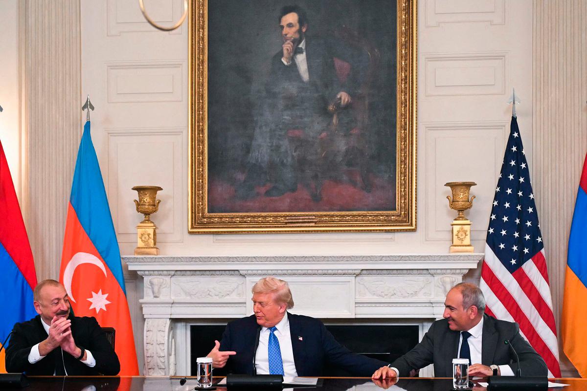 US President Donald Trump (C), Azerbaijani President Ilham Aliyev (L) and Armenian Prime Minister Nikol Pashinyan react after signing an agreement in the State Dining Room of the White House in Washington, DC on August 8, 2025. - ANDREW CABALLERO-REYNOLDS / AFP