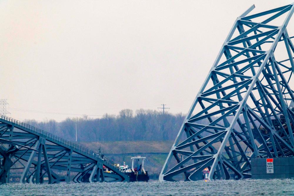 The collapsed Francis Scott Key Bridge sits in the water after being struck by a cargo ship March 27, 2024 in Baltimore, Maryland/AFPPix