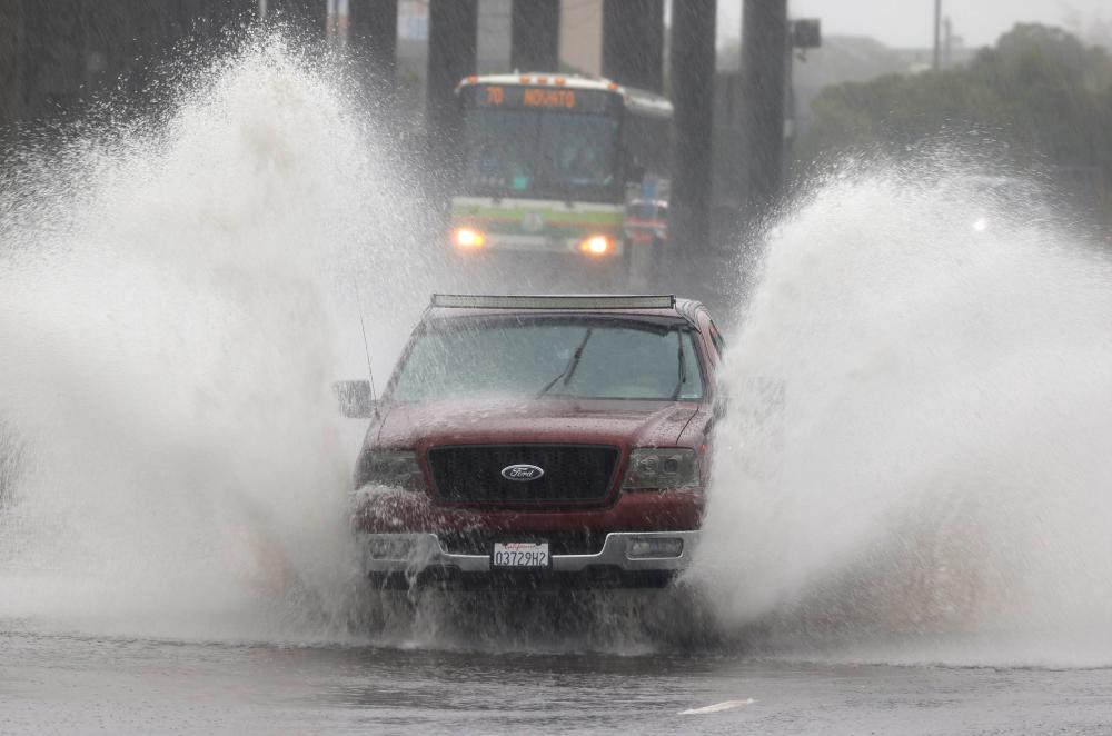 Water kicks up as a truck drives on a flooded street on October 24, 2021 in Mill Valley, California. A category 5 atmospheric river is bringing heavy precipitation, high winds and power outages to the San Francisco Bay Area. The storm is expected to bring anywhere between 2 to 5 inches of rain to many parts of the area. AFPpix