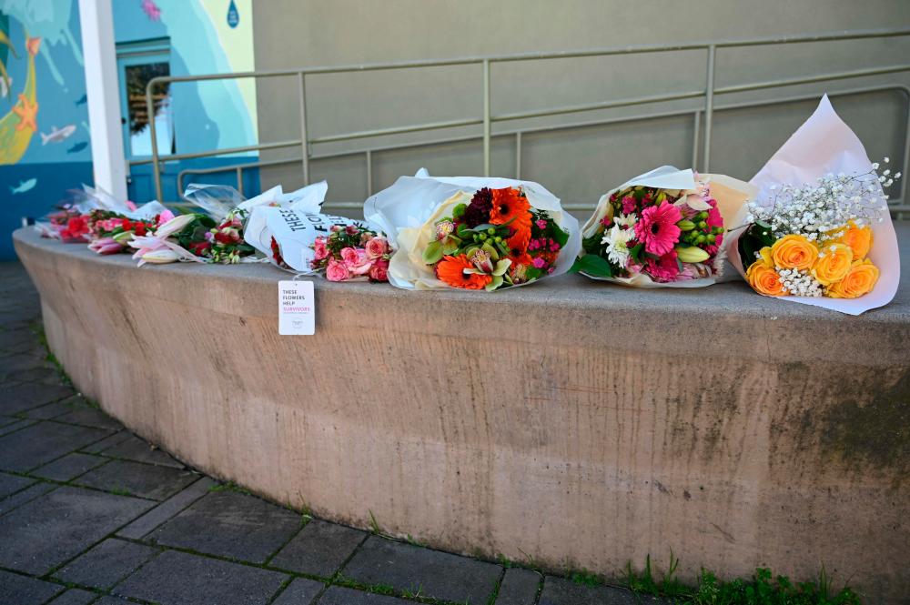 A row of bouquets placed across the street from the Half Moon Bay city hall in honor of the shooting victims in Half Moon Bay, California, on January 24, 2023/AFPPix