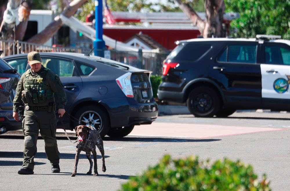 A police officer leads a canine at the scene of a shooting at the Geneva Presbyterian Church on May 15, 2022 in Laguna Woods, California. AFPPIX