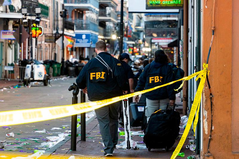 FBI investigators arrive at the scene where the white Ford F-150 pickup truck that crashed into a work lift after allegedly driving into a crowd of New Year’s revelers in the French Quarter of New Orleans, Louisiana, on January 1, 2025. At least 10 people were killed and 30 injured Wednesday when a vehicle plowed overnight into a New year’s crowd in the heart of the thriving New Orleans tourist district, authorities in the southern US city said. - Matthew HINTON / AFP