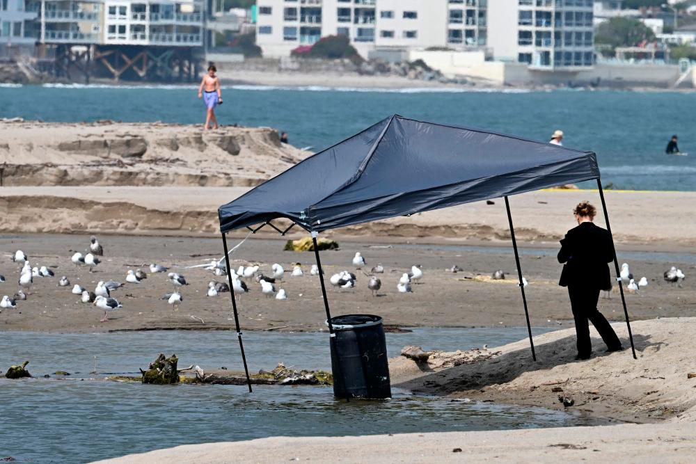 An investigator stands next to a barrel where a body was discovered in Malibu Lagoon State Beach, California on July 31, 2023. AFPPIX