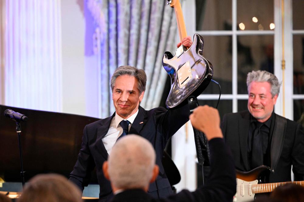 US Secretary of State Antony Blinken holds up a guitar after performing during a celebration marking the launch of the Music Diplomacy Initiative in the Benjamin Franklin Room of the State Department in Washington, DC, on September 27, 2023/AFPPix