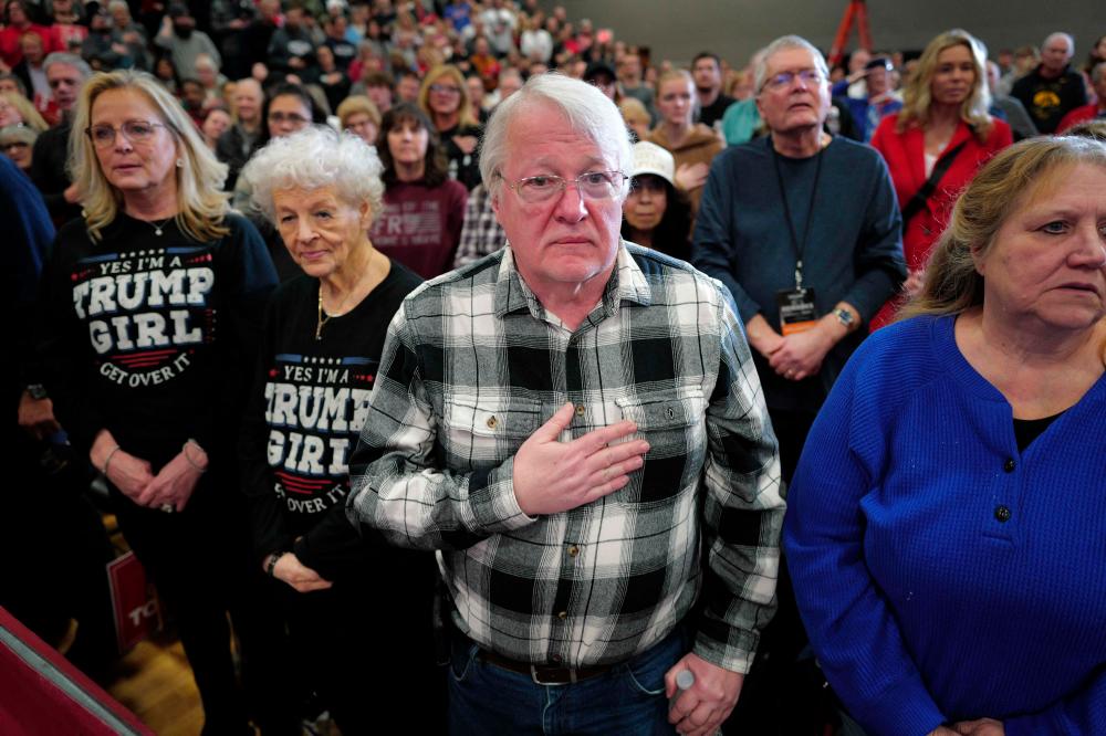 Guests listen to the national anthem during a rally with Republican presidential candidate former President Donald Trump at Clinton Middle School on January 06, 2024 in Clinton, Iowa/AFPpix