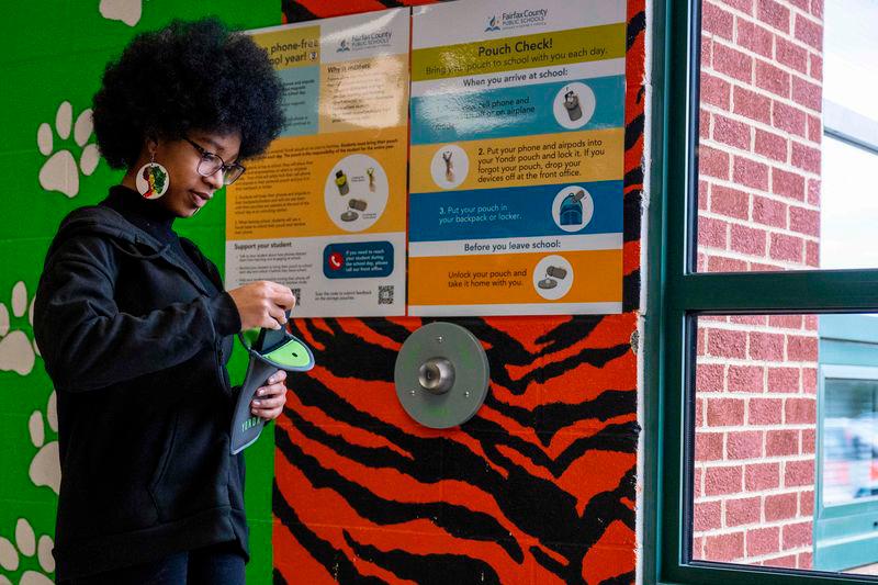 Eighth-grader Ja’ Nae Dorsey unlocks her cell phone pouch after school at Mark Twain Middle School in Alexandria, Virginia - AFPPIX