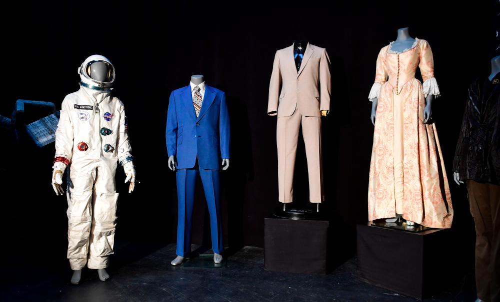 $!Items up for auction at the Prop Store Auction in late August are on display July 15, 2020, at the Prop Store in Valencia, California, including from (L-R), Neil Armstrong’s spacesuit worn by Ryan Gosling in the film “First Man”, the Blue suit worn by Will Farrell in the film “Anchorman”, a suit worn by Al Pacino in the film “Godfather 2”, and a dress worn by Keira Knightly in the film “Pirates of the Caribbean.” / AFP / Frederic J. BROWN / TO GO WITH AFP STORY by Ben SHEPPARD -- “’Top Gun’ helmet and ‘Alien’ spaceship in Hollywood props auction”