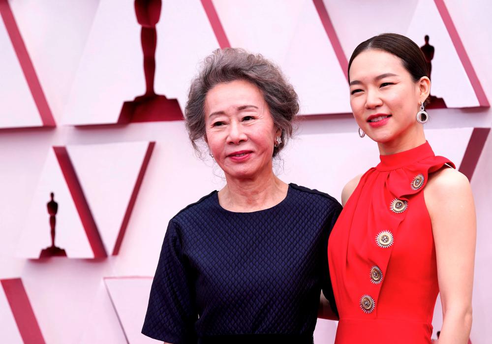 Youn Yuh-Jung and actress Han Ye-ri (R) arrive at the Oscars on April 25, 2021, at Union Station in Los Angeles. -AFP