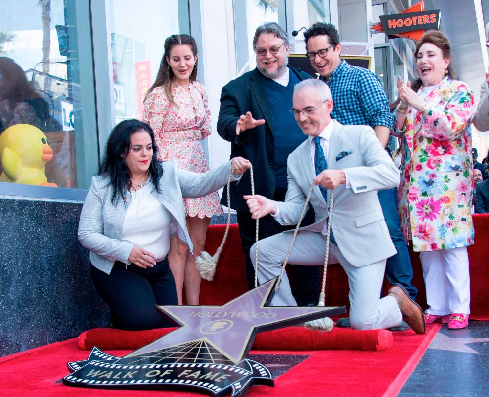(L-R standing) Singer/songwriter Lana Del Rey, directors Guillermo Del Toro and J.J. Abrams attend the ceremony honoring Del Toro with a Star on The Hollywood Walk of Fame, in Hollywood, California, on August 6, 2019. / AFP / VALERIE MACON