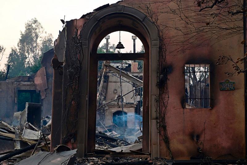 The entryway of a damaged home is seen after the passage of the Palisades Fire in Pacific Palisades, California, on January 8, 2025. At least five people have been killed in wildfires rampaging around Los Angeles, officials said on January 8, with firefighters overwhelmed by the speed and ferocity of multiple blazes. - AGUSTIN PAULLIER / AFP