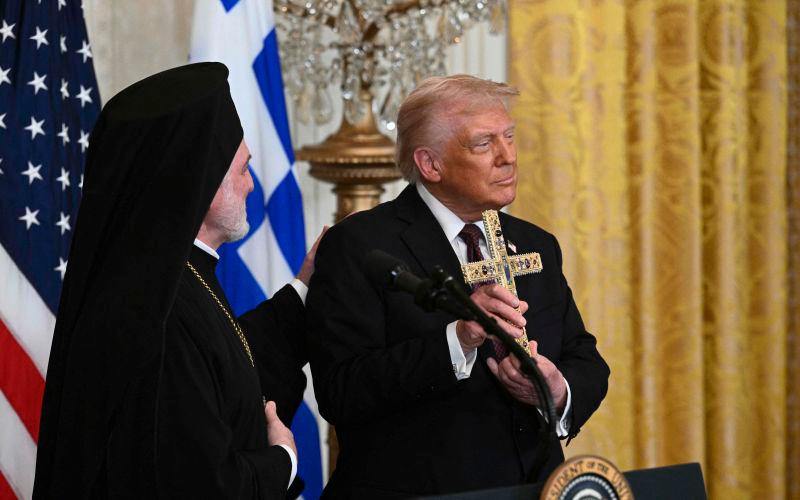 Trump displays a cross given to him by Elpidophoros of America (L), a bishop of the Ecumenical Patriarchate of Constantinople, during a Greek Independence Day celebration in the East Room of the White House in Washington, DC, AFPpix