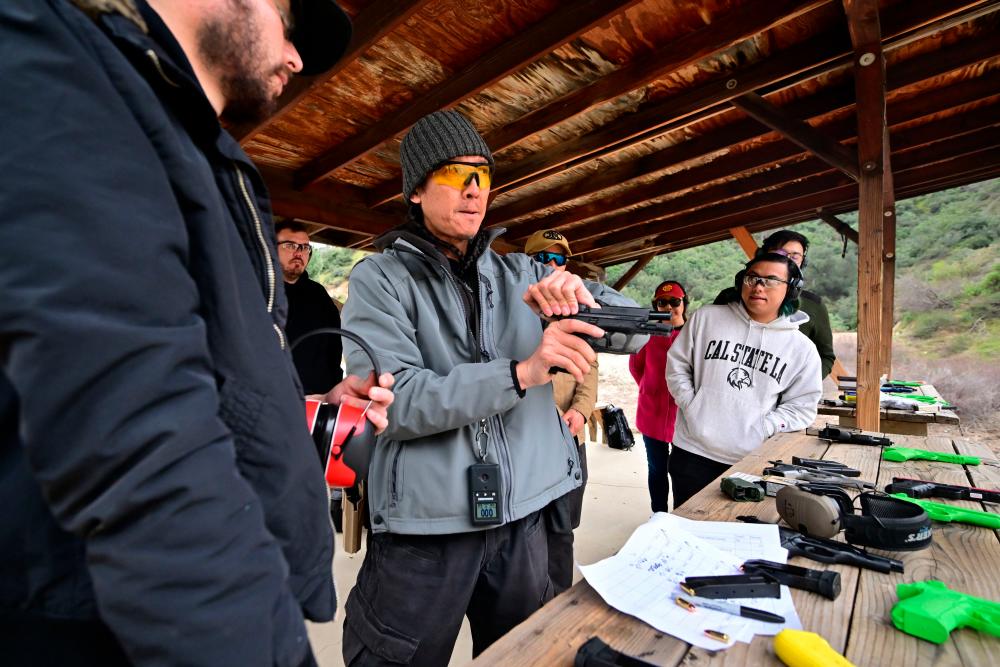Gun instructor Tom Nguyen (C) teaches students during a Defensive Pistol Class at Burro Canyon Shooting Park in Azusa, California on February 12, 2023. AFPPIX