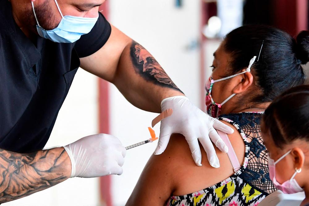 The Pfizer Covid-19 vaccine is administered at a mobile clinic in an East Los Angeles neighborhood -AFP