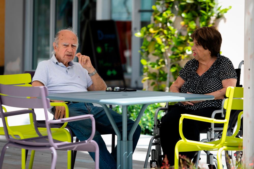 Seniors sit outside a cafe in West Palm Beach, Florida, on March 12, 2020. - AFP