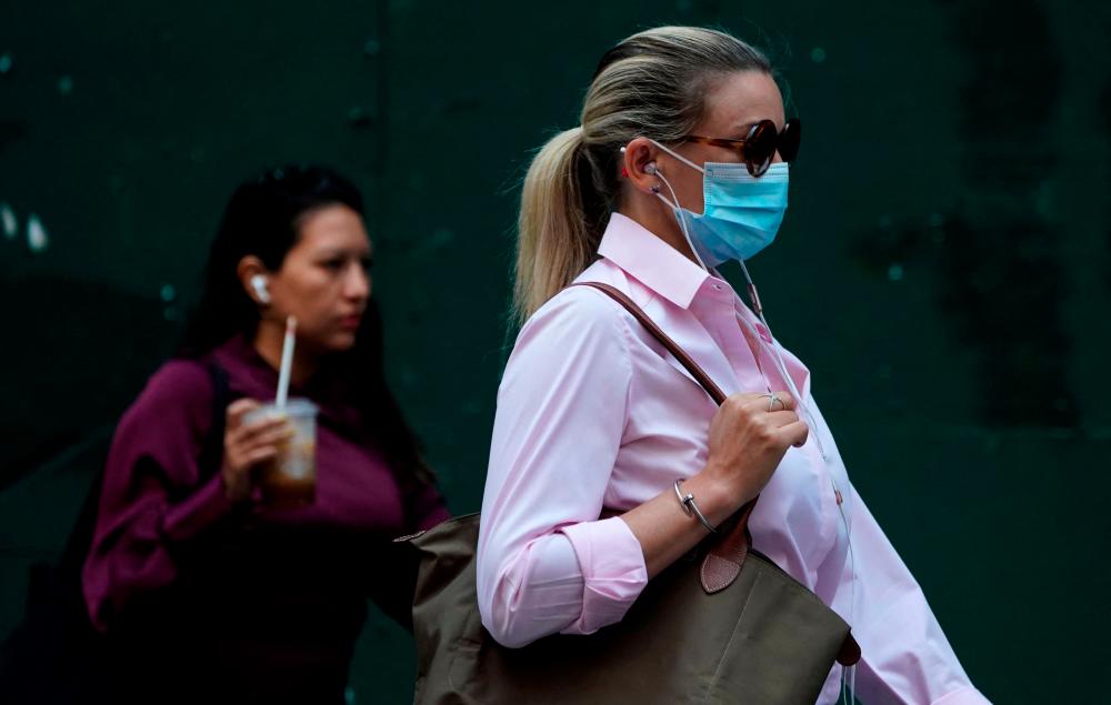 People walk through Times Square on July 22, 2021, as the Delta Covid surge is renewing calls for mask mandates in New York. -AFP