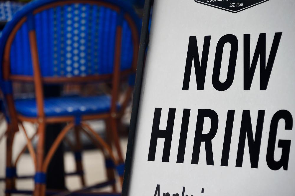 A sign in a restaurant in Arlington, Virginia, on Tuesday. Small businesses with less than 50 employees added 63,000 jobs in July, ADP said – AFPPIX