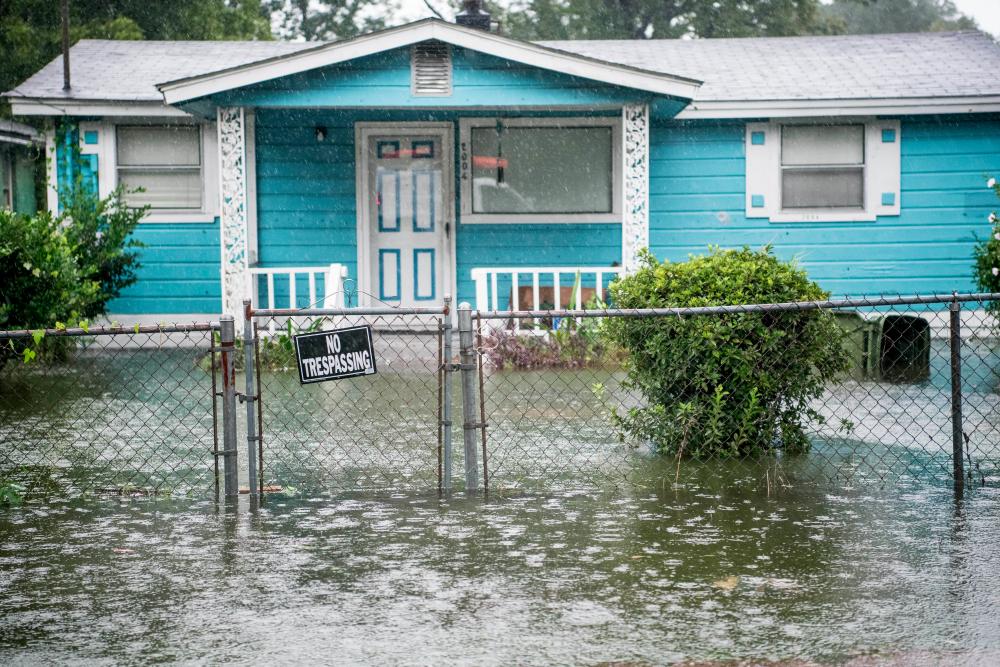 Flood water accumulates in the front yard of a home on September 5, 2019 in Georgetown, South Carolina. — AFP