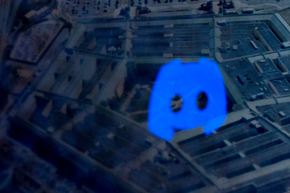 This photo illustration created on April 13, 2023 shows the Discord logo reflected in an image of the Pentagon in Washington, DC. FBI agents arrested a young national guardsman, Jack Teixeira, suspected of being behind a major leak of sensitive US government secrets -- including about the Ukraine war/AFPPix